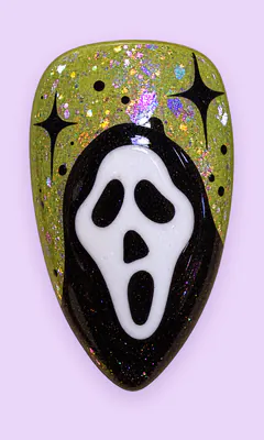 Uña con la máscara de Scream sobre glitter verde.