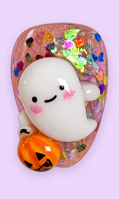 Uña rosa traslúcida con fantasma en 3D y una calabaza.